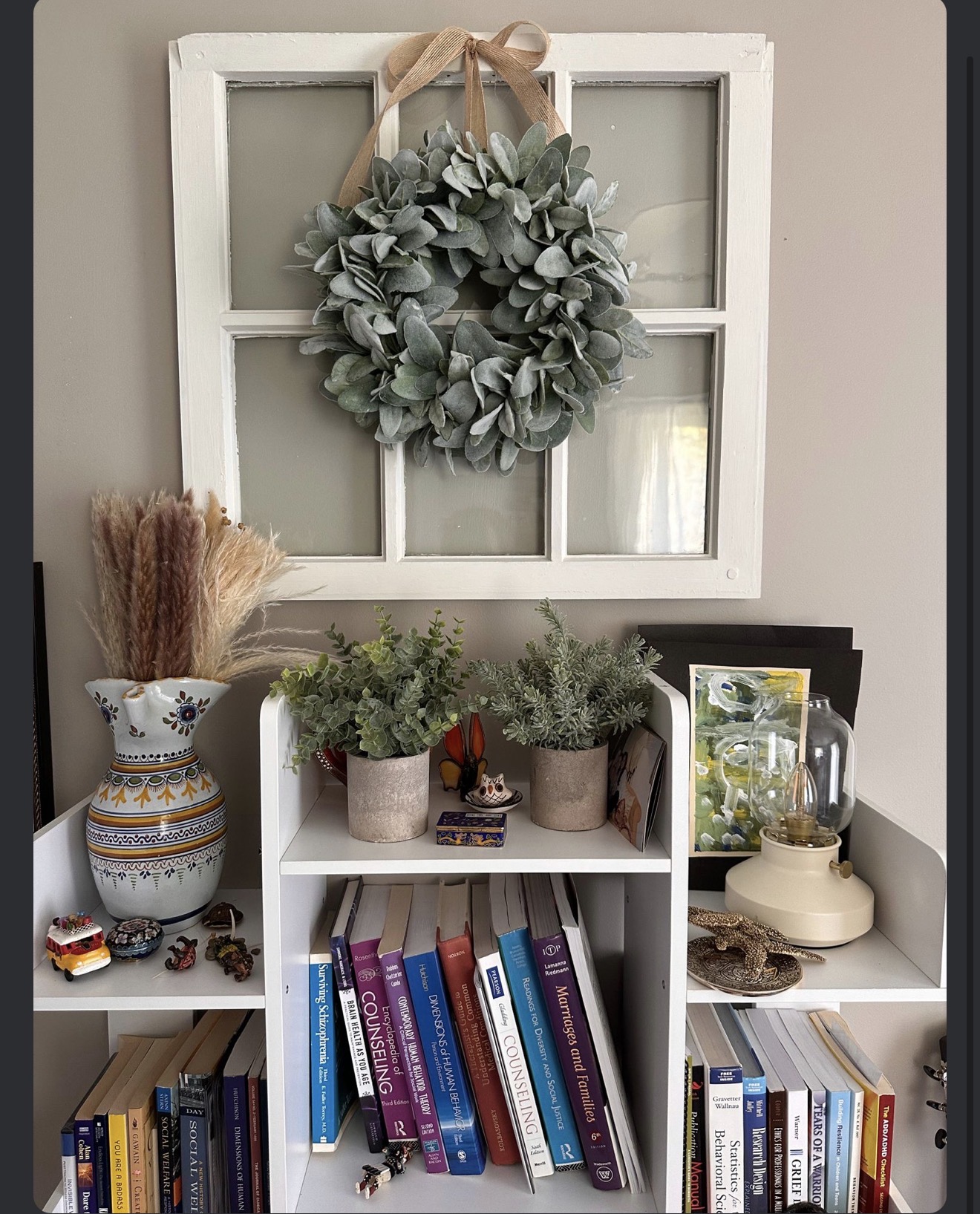 A welcoming corner with books, plants, and a leafy wreath